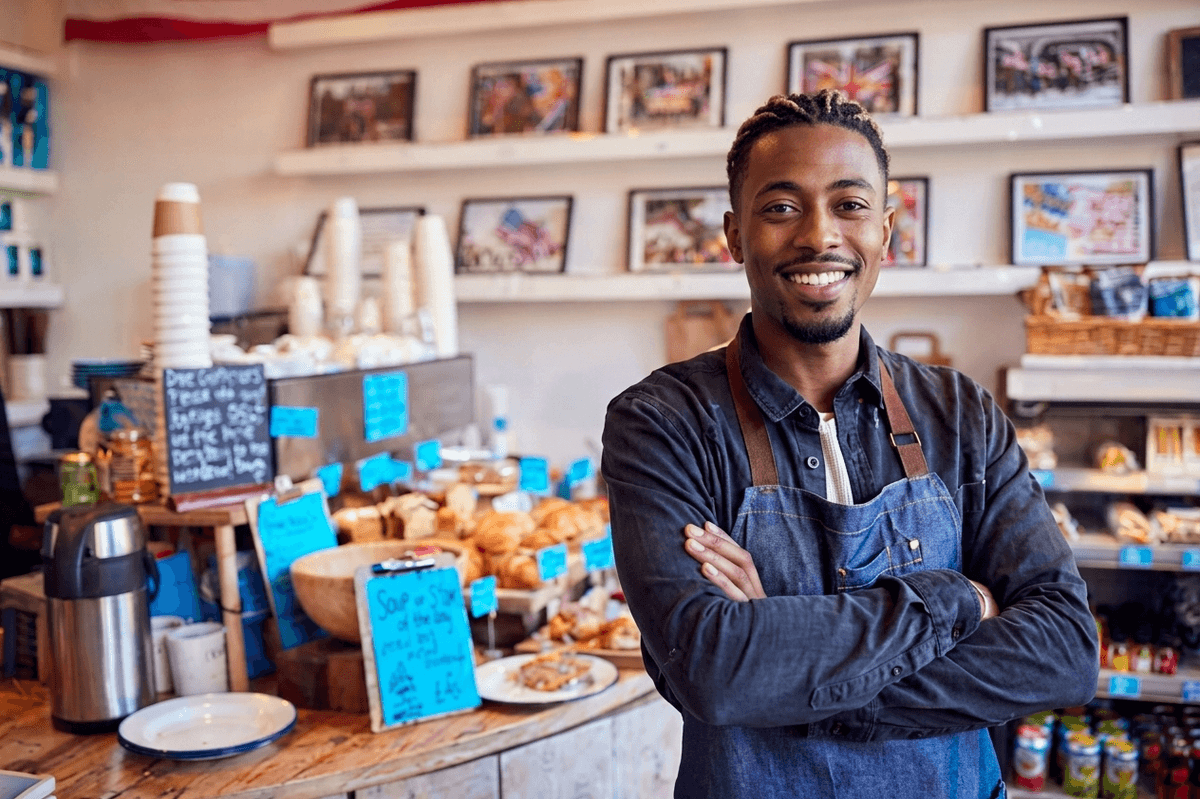 Commerçant WIVO souriant, bras croisés, dans sa boulangerie-café